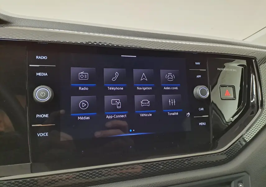Écran tactile central du Volkswagen Taigo 2025, affichant les options radio, téléphone, navigation et aides à la conduite.