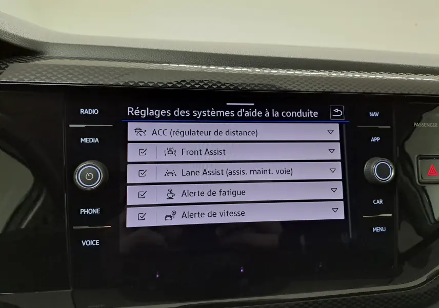 Écran tactile central du Volkswagen Taigo 2025 affichant les réglages des aides à la conduite, avec boutons autour.