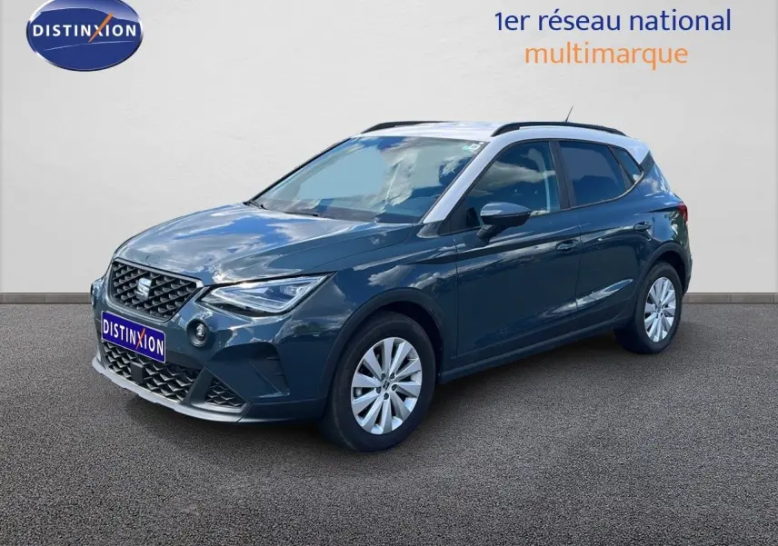 SEAT Arona bleu Fjord avec toit blanc, vue 3/4 avant droit, mettant en valeur ses lignes dynamiques et jantes argentées.