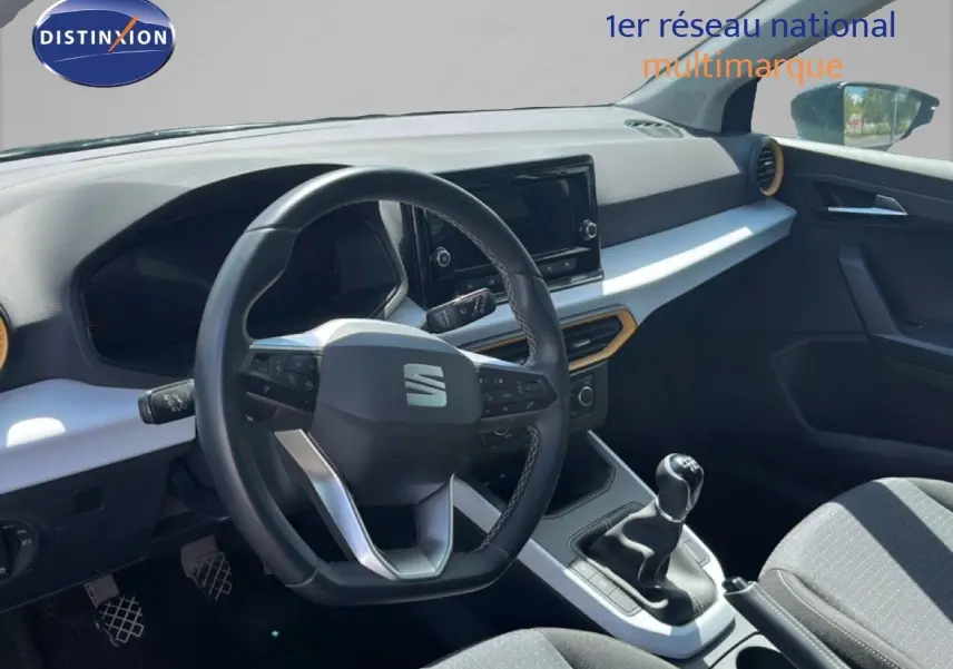 Intérieur de la SEAT Arona 2025 vu côté conducteur, volant multifonction et levier de vitesse manuel en vue rapprochée.