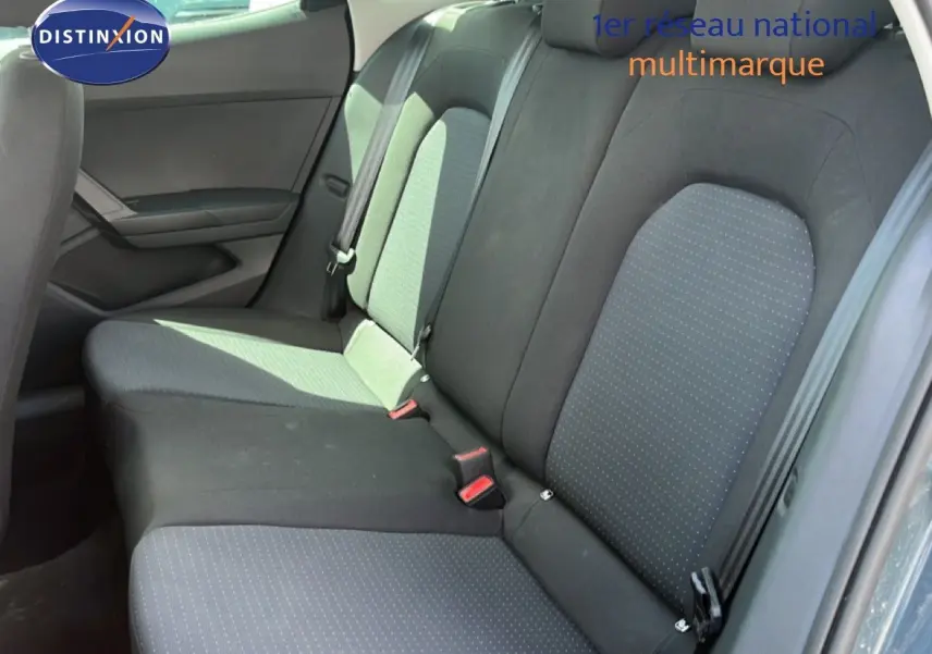 Vue latérale intérieure montrant la banquette arrière en tissu gris et noir du SEAT Arona 2025.