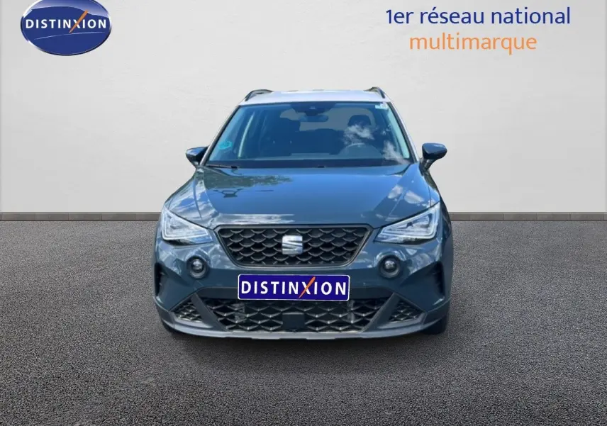 Vue avant d'un SEAT Arona bleu Fjord avec toit blanc, calandre noire et phares LED allumés.