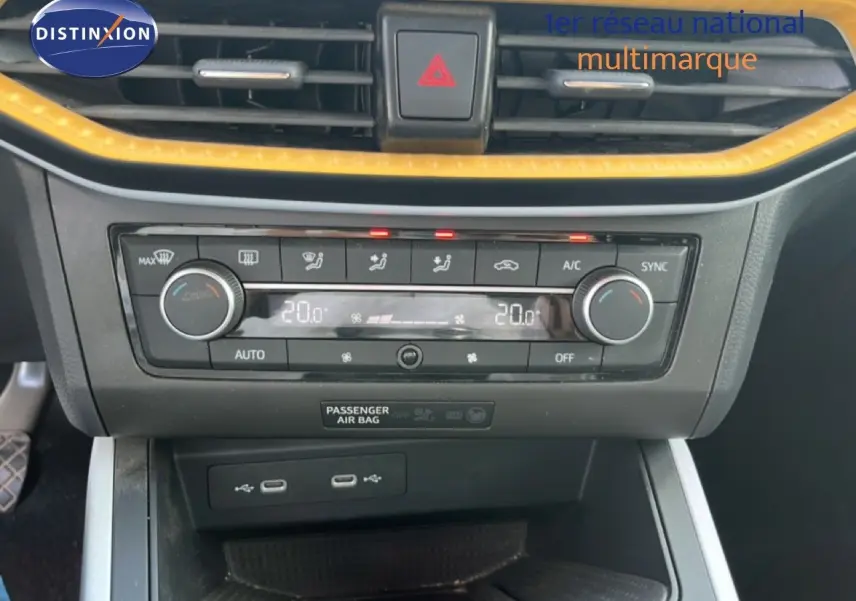 Vue rapprochée de la console centrale du SEAT Arona 2025, avec climatisation digitale et finitions jaunes contrastantes.