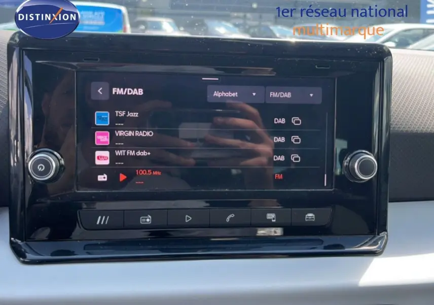 Écran tactile central du SEAT Arona 2025 affichant les stations radio FM/DAB, avec tableau de bord gris et noir.