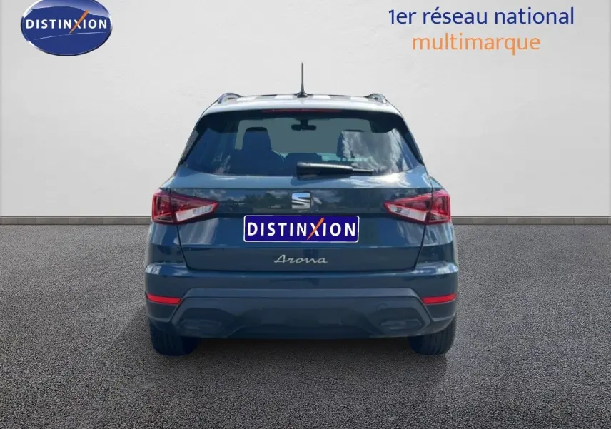 Vue arrière du SEAT Arona bleu Fjord avec toit blanc, version Style Special Edition 2025, sur sol gris.
