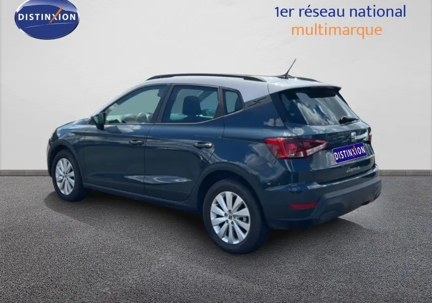 SEAT Arona bleu Fjord avec toit blanc, vue 3/4 arrière droit, jantes alliage et feux arrière LED visibles.