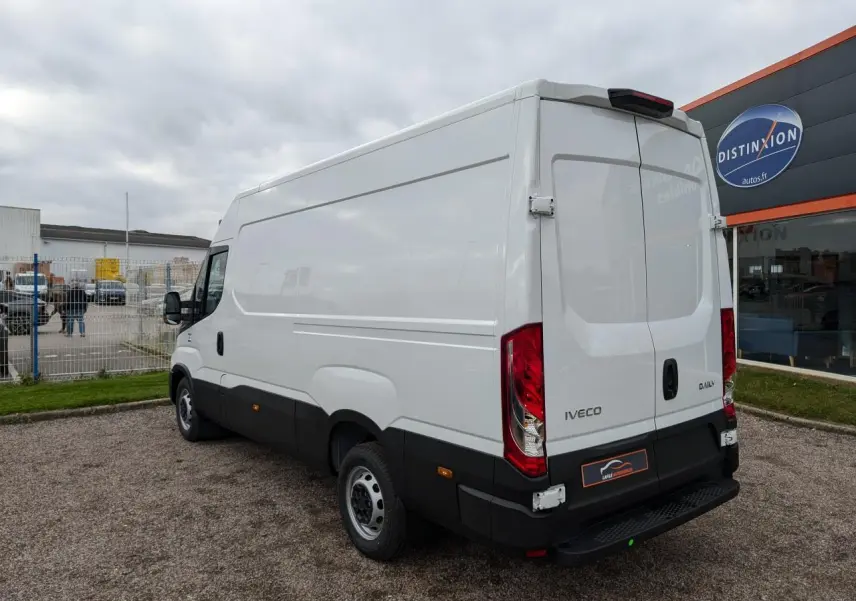 Vue 3/4 arrière droite d’un fourgon Iveco Daily blanc avec portes arrière fermées et marchepied noir visible.