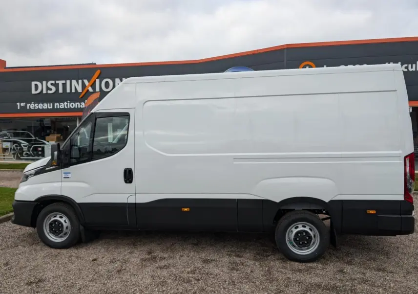 Vue latérale droite d'un utilitaire Iveco Daily blanc avec bas de caisse noir et porte coulissante sans fenêtre.
