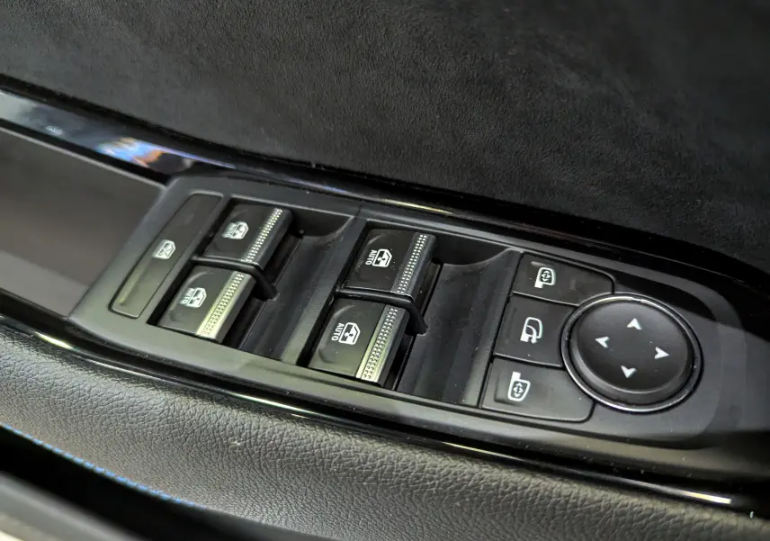 Gros plan sur les commandes des vitres et rétroviseurs côté conducteur du Renault Austral blanc nacré 2023.