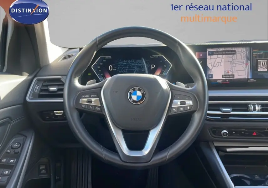 Vue intérieure centrée sur le volant cuir noir et le tableau de bord digital d'une BMW Série 3 Touring F31 316d.