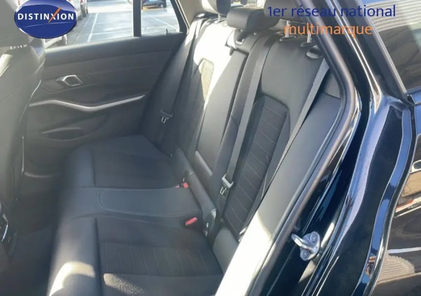 Vue intérieure côté droit sur les sièges arrière en cuir noir d'une BMW Série 3 Touring F31 noire, avec ceinture de sécurité visible.