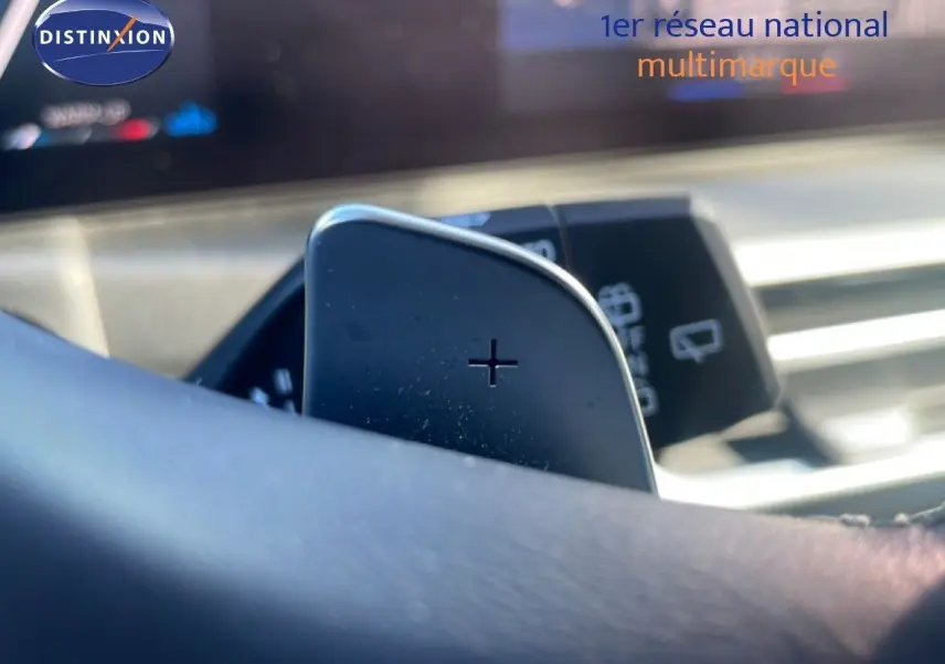 Gros plan sur la palette de changement de vitesse + au volant d’une BMW Série 3 Touring 316D noir sapphire, intérieur moderne.