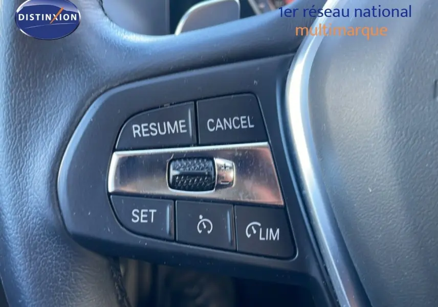 Gros plan sur les commandes de régulateur de vitesse au volant cuir noir d’une BMW Série 3 Touring F31 noir saphir.
