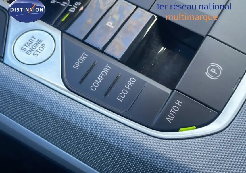 Gros plan sur la console centrale noire avec boutons de modes de conduite et démarrage dans une BMW Série 3 Touring F31.