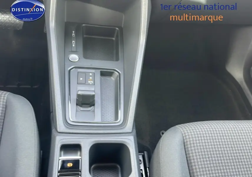 Vue plongeante sur la console centrale du Volkswagen Caddy 2025, avec levier de vitesse automatique et sièges tissu noir à motif quadrillé.