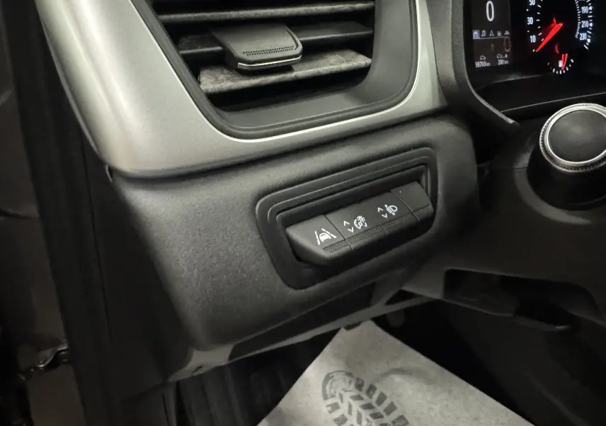 Détail intérieur du tableau de bord côté gauche du Renault Captur gris foncé, avec commandes d'assistance à la conduite visibles.
