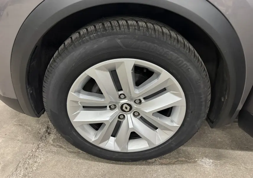 Gros plan sur la roue avant gauche du Renault Captur gris foncé, avec jante alliage et pneu Bridgestone.