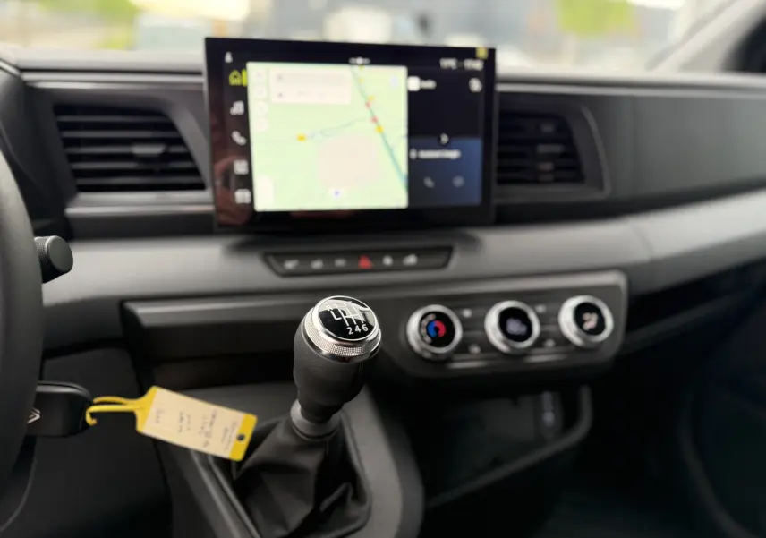 Gros plan sur le levier de vitesses manuel du Renault Master 2024 avec écran tactile et commandes de climatisation visibles.