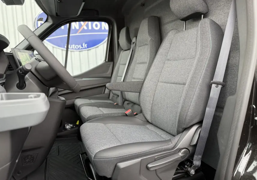 Intérieur côté conducteur du Renault Master 2024 noir nacré, montrant les sièges gris avec accoudoir et ceinture de sécurité.