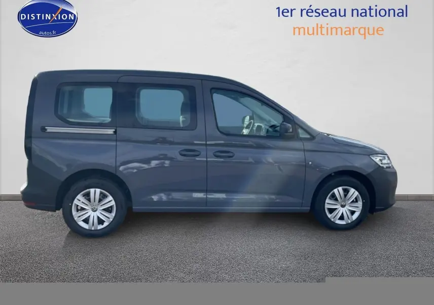 Profil latéral droit d'un Volkswagen Caddy gris pur 2025 avec vitres teintées et jantes alliage.