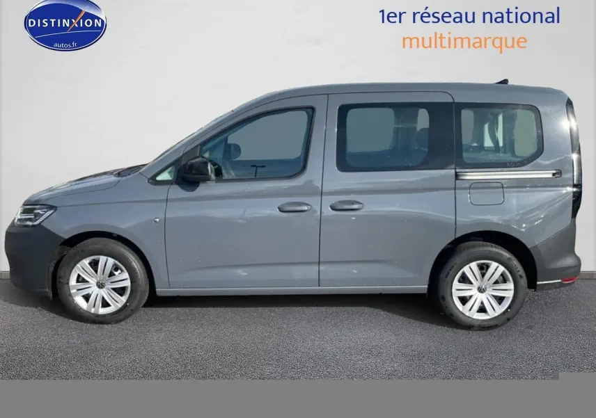 Profil droit d'un Volkswagen Caddy gris pur 2025 avec vitres teintées et jantes alliage.