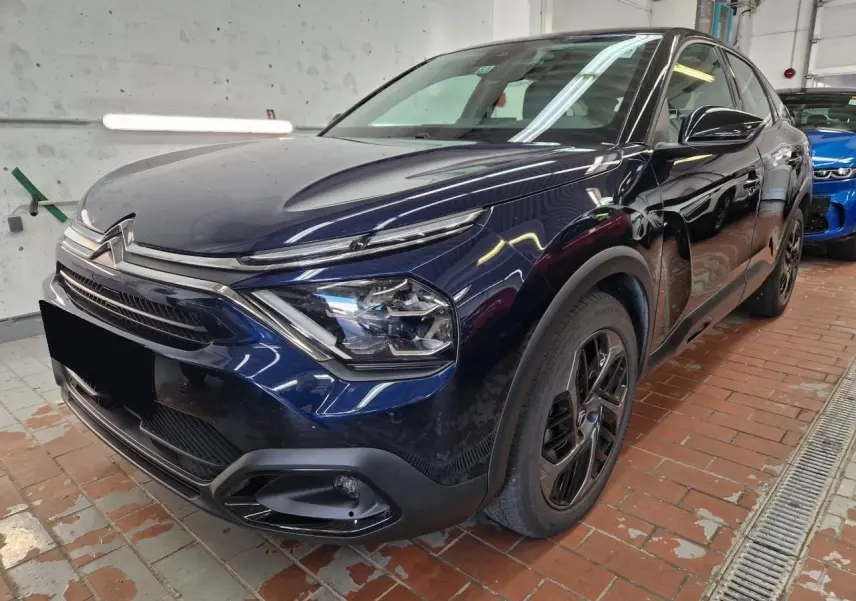 Citroën C4 2024 bleu Eclipse en 3/4 avant droit, avec toit noir et jantes alliage 18 pouces distinctives.