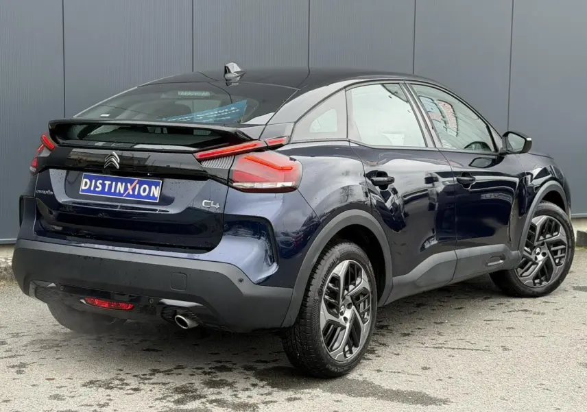 Vue 3/4 arrière droite de la Citroën C4 2024 bleu Eclipse avec toit noir Perla et jantes alliage 18 pouces.