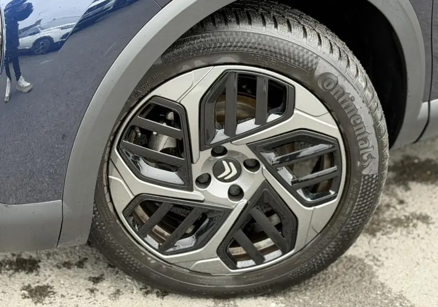 Gros plan sur la roue avant droite de la Citroën C4 2024 Bleu Eclipse avec jante alliage 18 pouces Aeroblade.