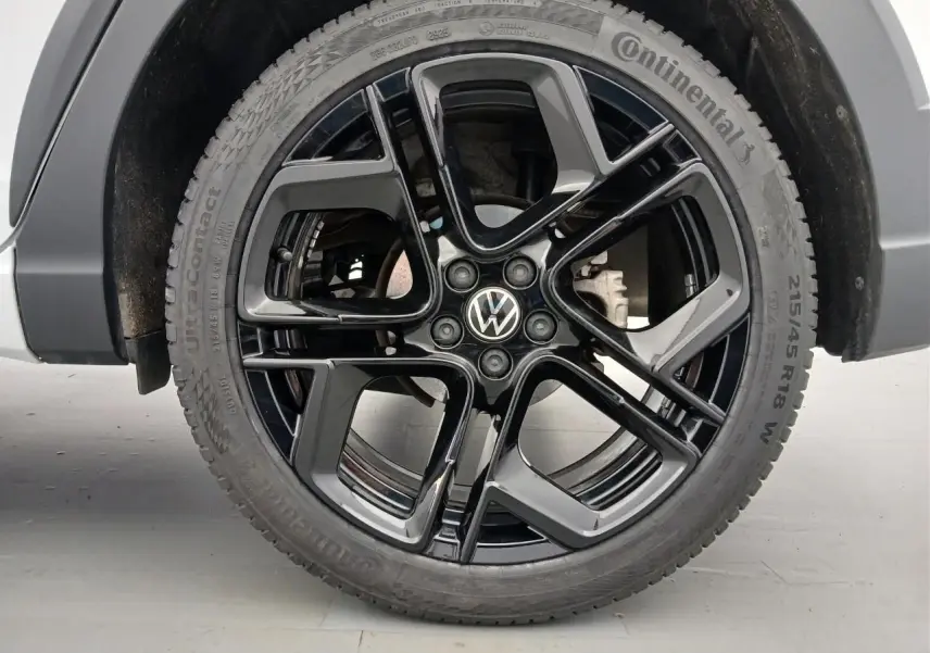 Gros plan sur la jante noire en alliage léger 18 pouces York du Volkswagen Taigo blanc pur, avec pneu Continental.