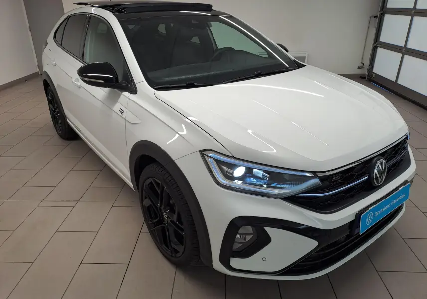 Volkswagen Taigo blanc pur avec toit noir, vue 3/4 avant droit, jantes noires et phares LED allumés.