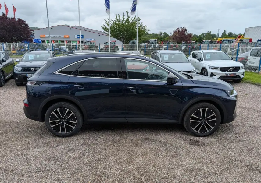 Profil côté gauche du SUV DS7 2024 bleu saphir métallisé avec jantes alliage noires et toit noir.