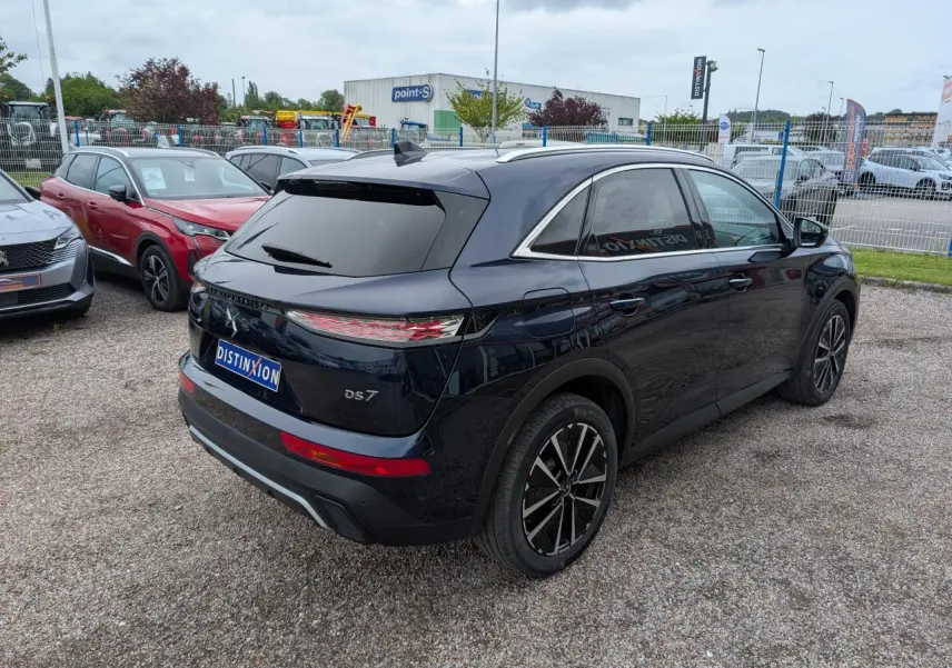 Vue 3/4 arrière droite d'un DS7 bleu métallisé avec feux arrière LED 3D et jantes alliage noires.
