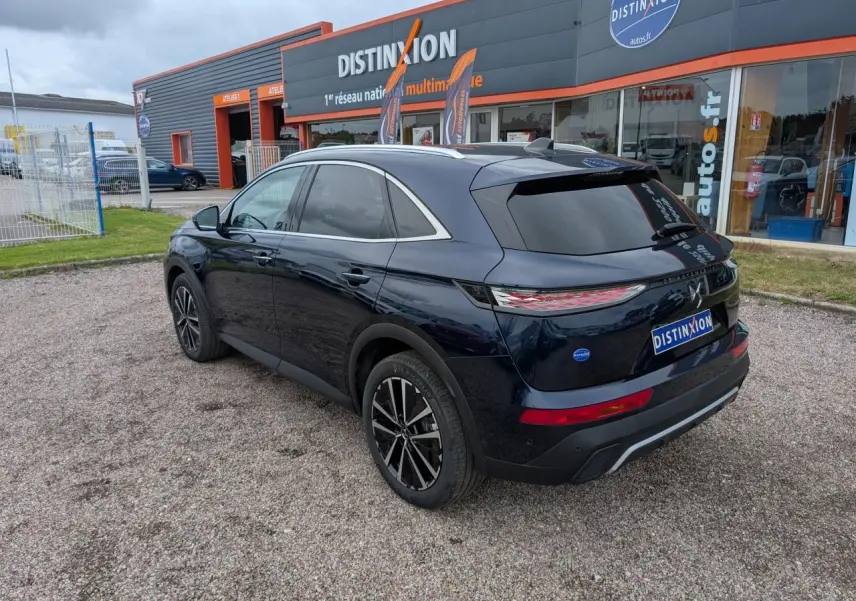 Vue 3/4 arrière droite du SUV DS7 2024 bleu métallisé avec jantes alliage noires et vitres teintées.