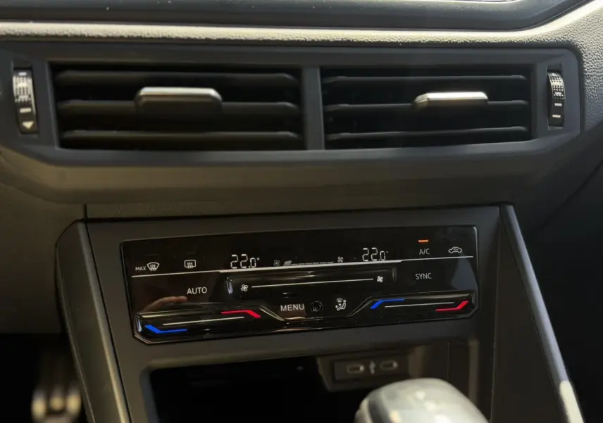 Détail de la console centrale avec climatisation automatique bi-zone et commandes tactiles dans un Volkswagen Taigo argent Reflex.