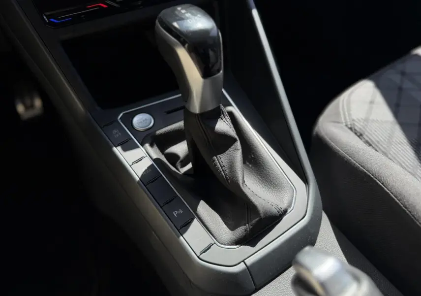 Gros plan sur la commande de la boîte automatique et le siège tissu gris du Volkswagen Taigo TSI 116 DSG R-Line 2025.