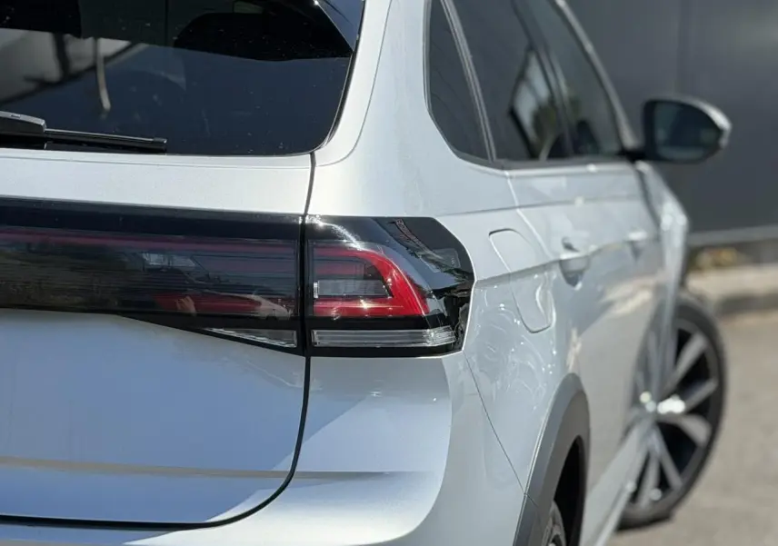 Vue arrière côté droit d’un Volkswagen Taigo TSI 116 DSG R-Line argent Reflex avec feux arrière LED et jantes alliage 18 pouces.