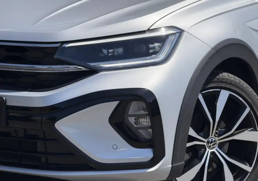 Gros plan sur l'avant droit du Volkswagen Taigo argent Reflex, mettant en valeur le phare Matrix LED et la jante alliage 18 pouces.