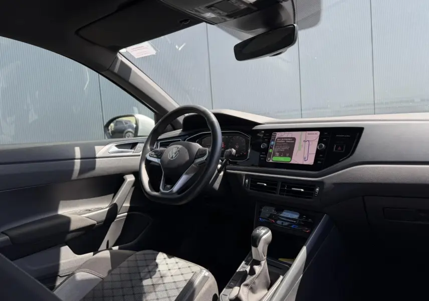 Vue intérieure côté conducteur du Volkswagen Taigo 2025, tableau de bord moderne avec écran tactile et volant multifonctions.