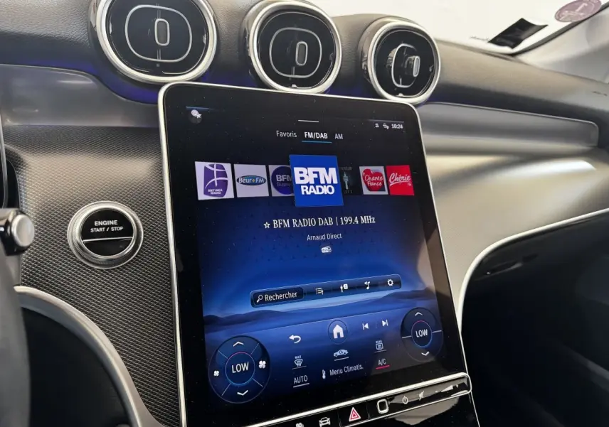 Vue rapprochée de l’écran tactile central et des aérateurs ronds du tableau de bord intérieur du Mercedes GLC gris foncé.