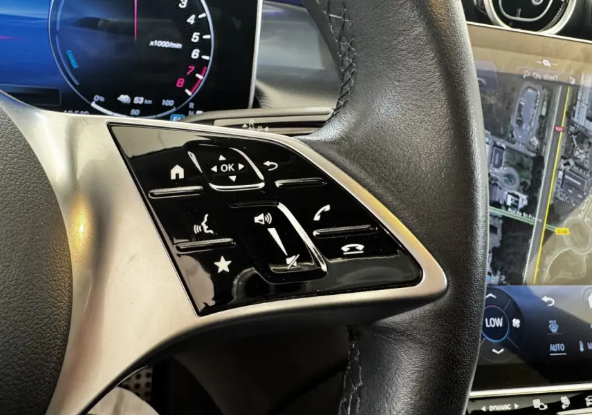 Gros plan sur le volant cuir noir et les commandes tactiles du Mercedes GLC 300 E Business Line 2023, écran tactile visible.