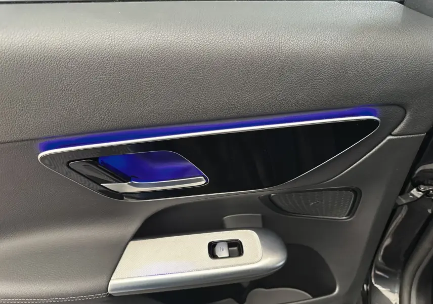 Gros plan sur la porte intérieure côté conducteur du Mercedes GLC 300 E Business Line 2023, avec éclairage d’ambiance bleu.