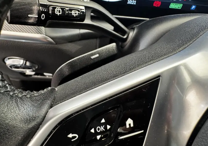 Gros plan sur les commandes noires et argentées du volant côté gauche du Mercedes GLC 300 E Business Line 2023.
