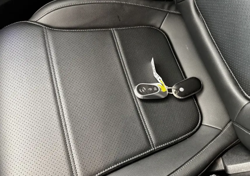 Gros plan sur la clé Mercedes posée sur un siège en cuir noir perforé de la Mercedes GLC 300 E Business Line 2023.