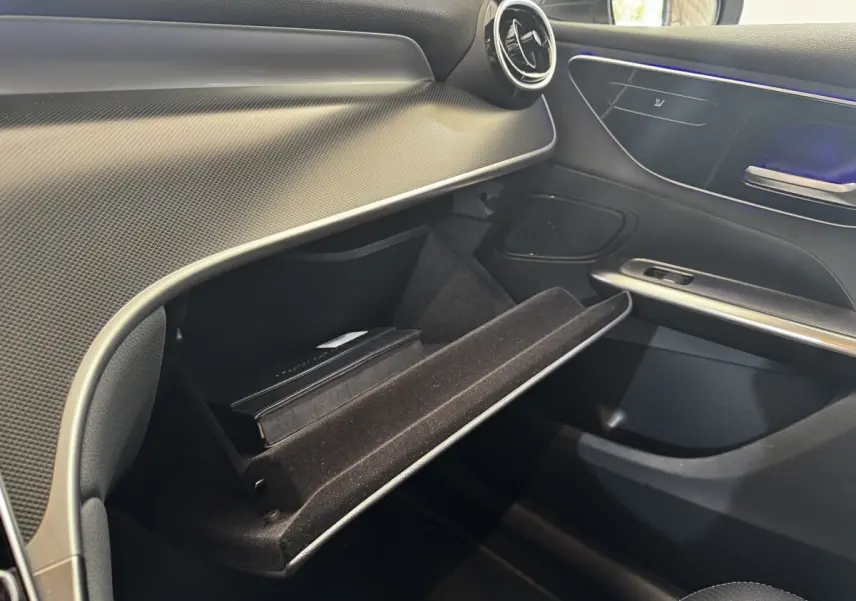 Vue intérieure côté passager du Mercedes GLC 300 E Business Line 2023, boîte à gants ouverte avec livret à l'intérieur.
