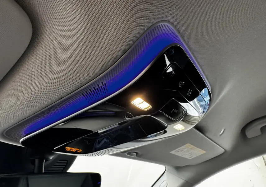 Plafonnier intérieur noir brillant avec éclairage LED et ambiance lumineuse bleue dans un Mercedes GLC gris foncé 2023.