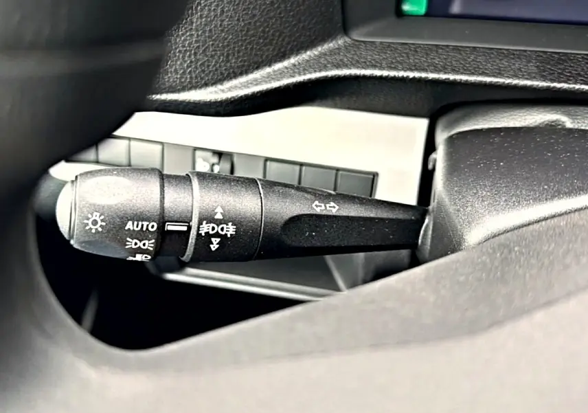 Gros plan sur la commande des phares et clignotants à gauche du volant dans un Fiat Scudo Combi gris titane 2026.