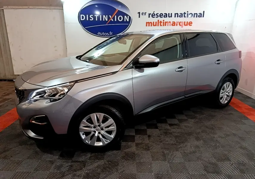 Peugeot 5008 gris foncé vue de profil droit en intérieur, mettant en valeur ses lignes modernes et ses jantes alliage.