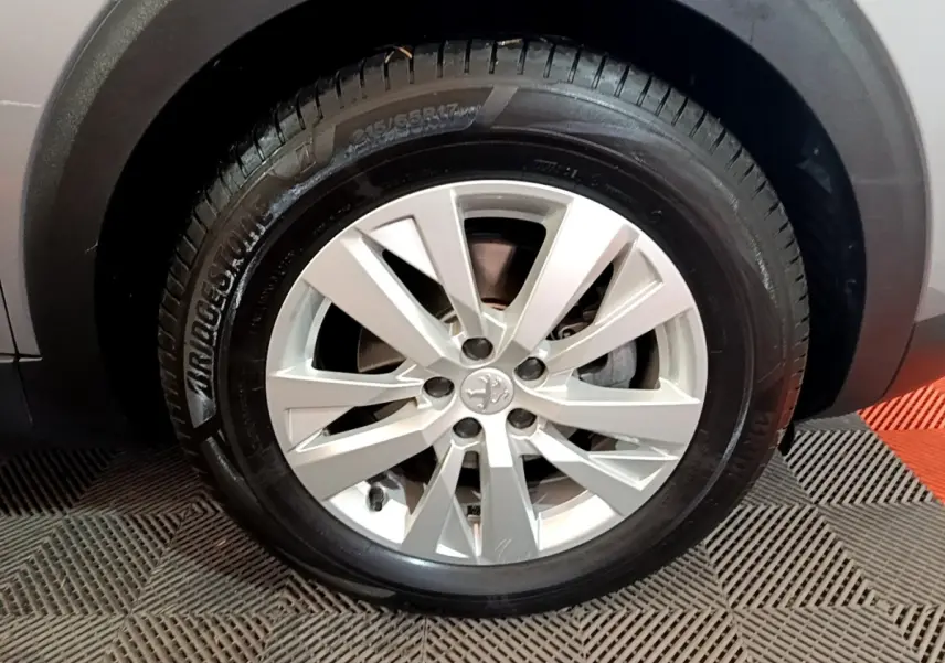 Gros plan sur la roue avant droite du Peugeot 5008 gris foncé, avec jante alliage et pneu Bridgestone.