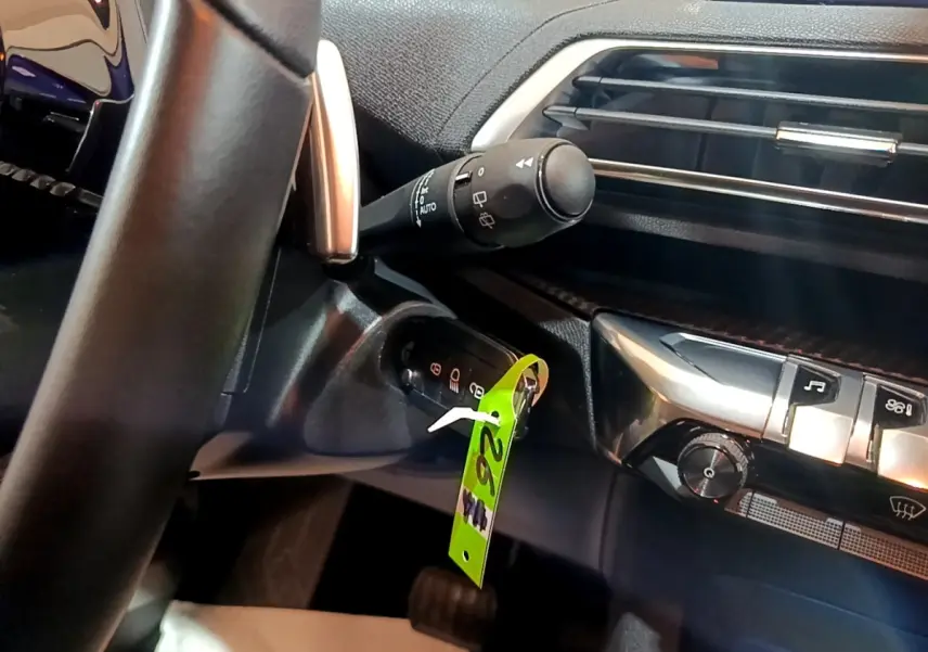 Détail intérieur du tableau de bord côté gauche du Peugeot 5008 2020, avec commande d’essuie-glace et clé insérée.