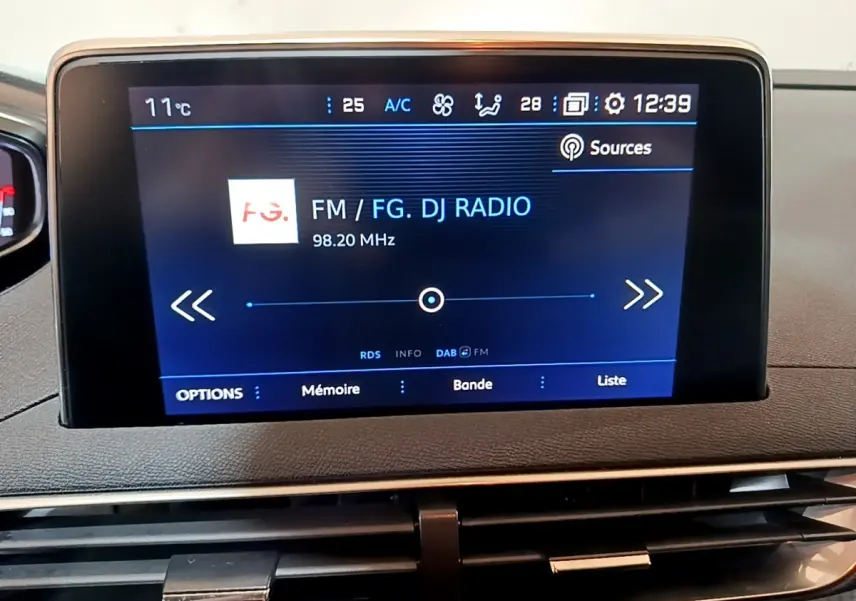 Écran tactile central du tableau de bord du Peugeot 5008 gris foncé, affichant une radio FM.